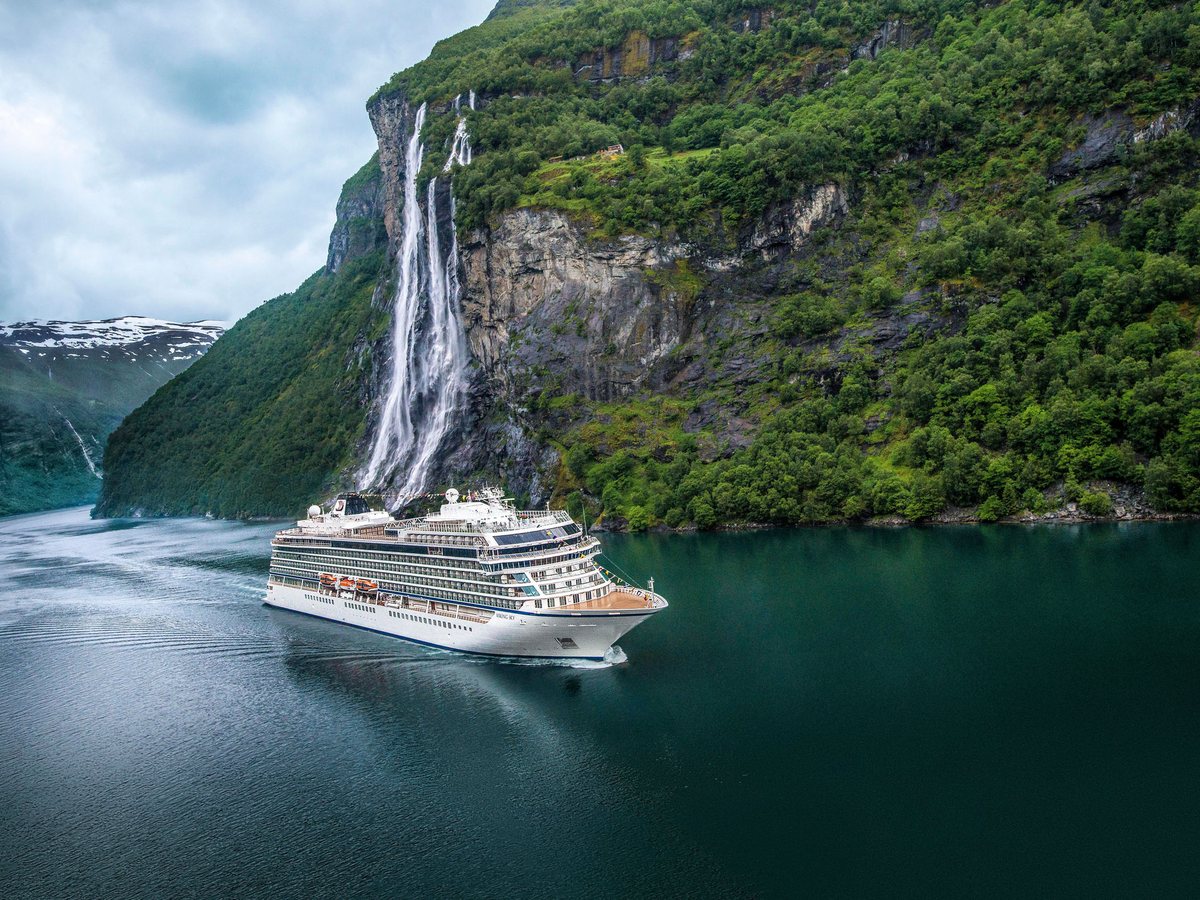 A Viking cruise ship passing a waterfall in Geirangerfjord, Norway
