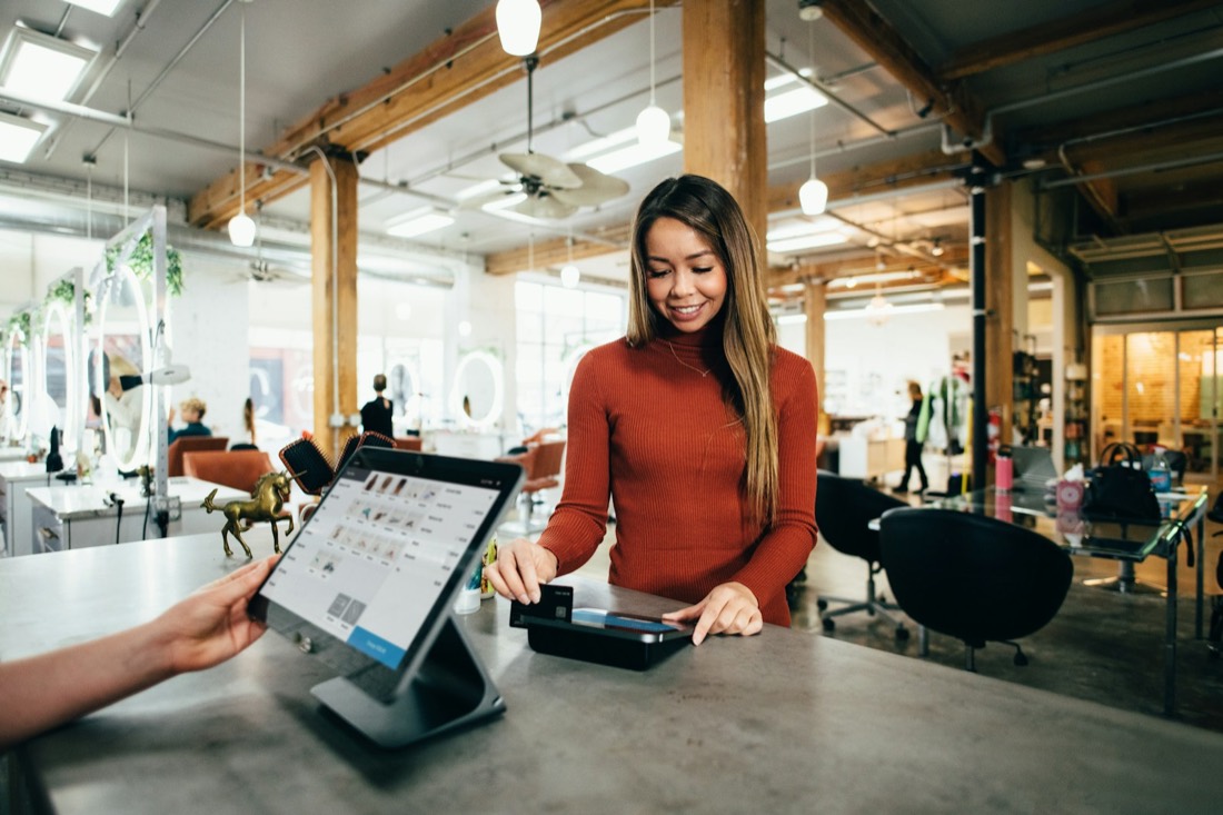 Retail associate completing a customer payment at a store counter