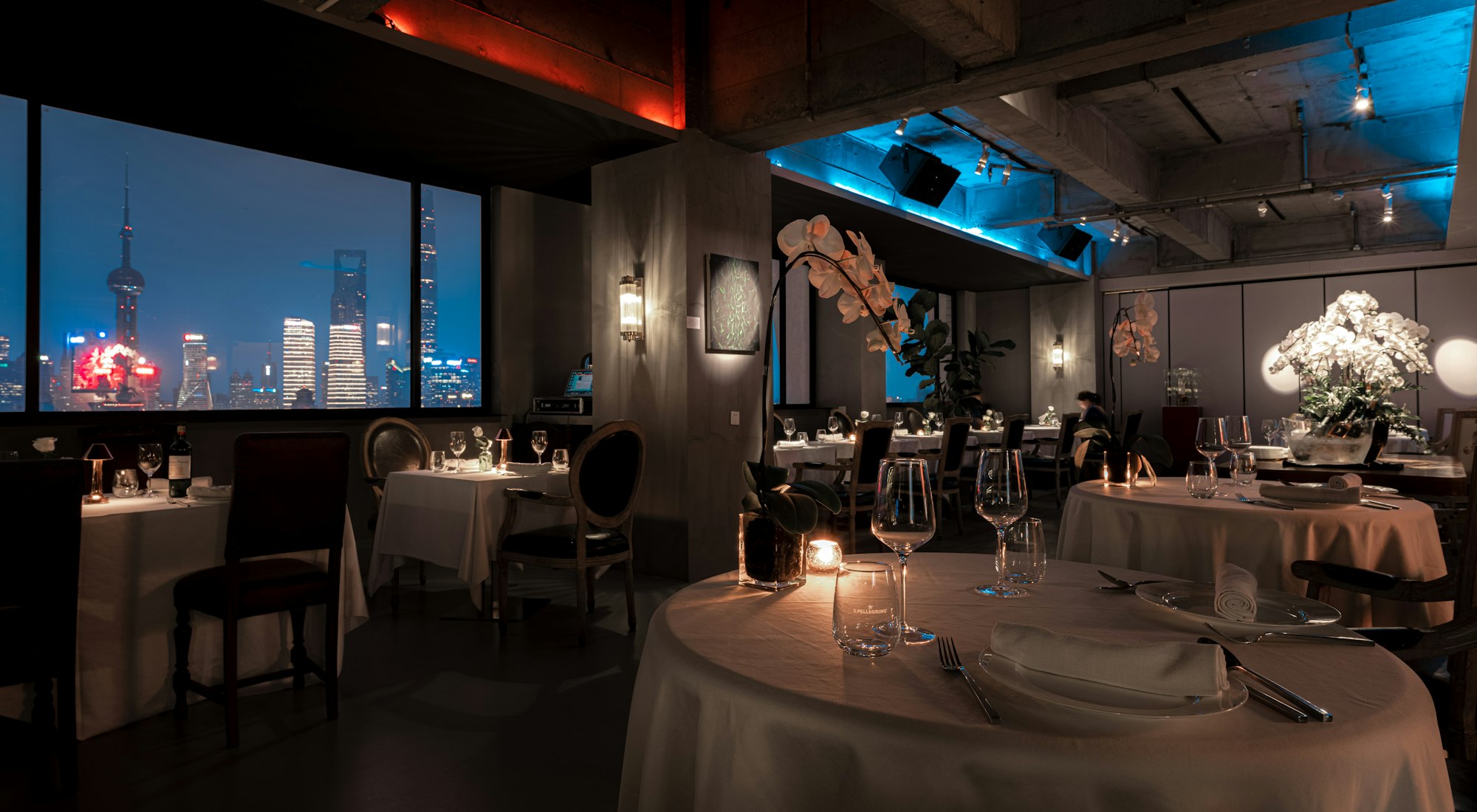Evening fine-dining restaurant with a city-skyline view &mdash; representative of the service-driven hospitality businesses Jobs Kreate recruits for