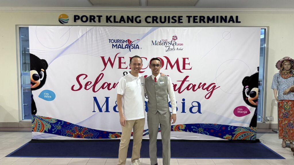 Keith from Jobs Kreate with a Genting Dream crew member at the Port Klang Cruise Terminal Welcome / Selamat Datang Malaysia backdrop.