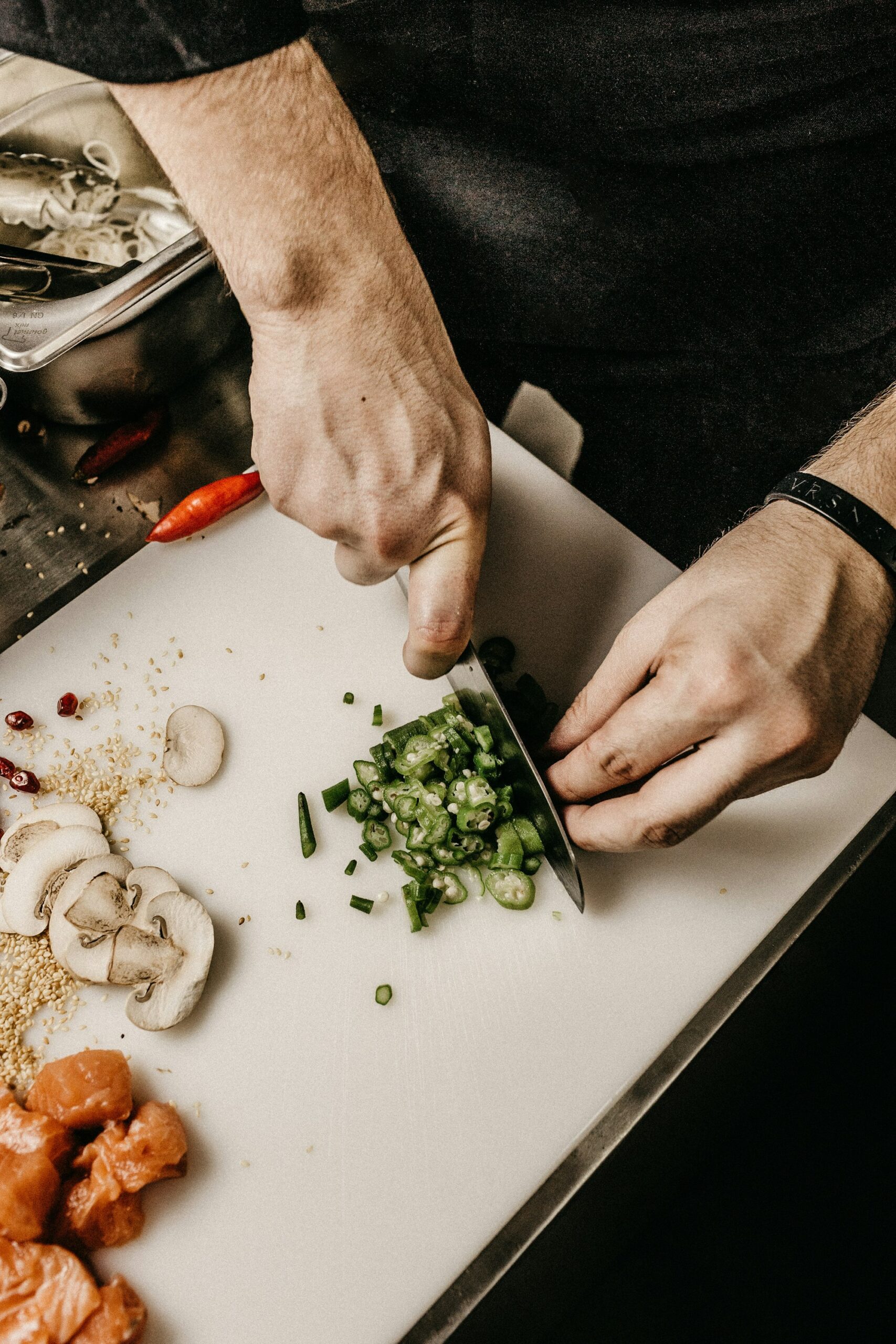 Hands preparing and chopping ingredients on a kitchen cutting board