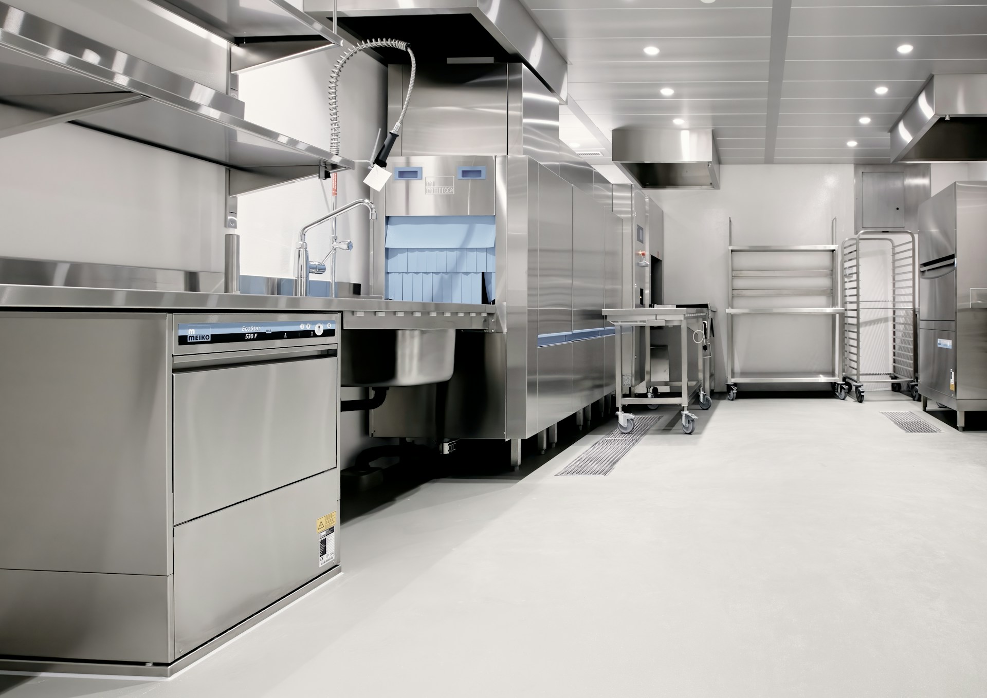 A clean stainless-steel commercial kitchen with preparation stations and equipment, similar to a cruise ship galley