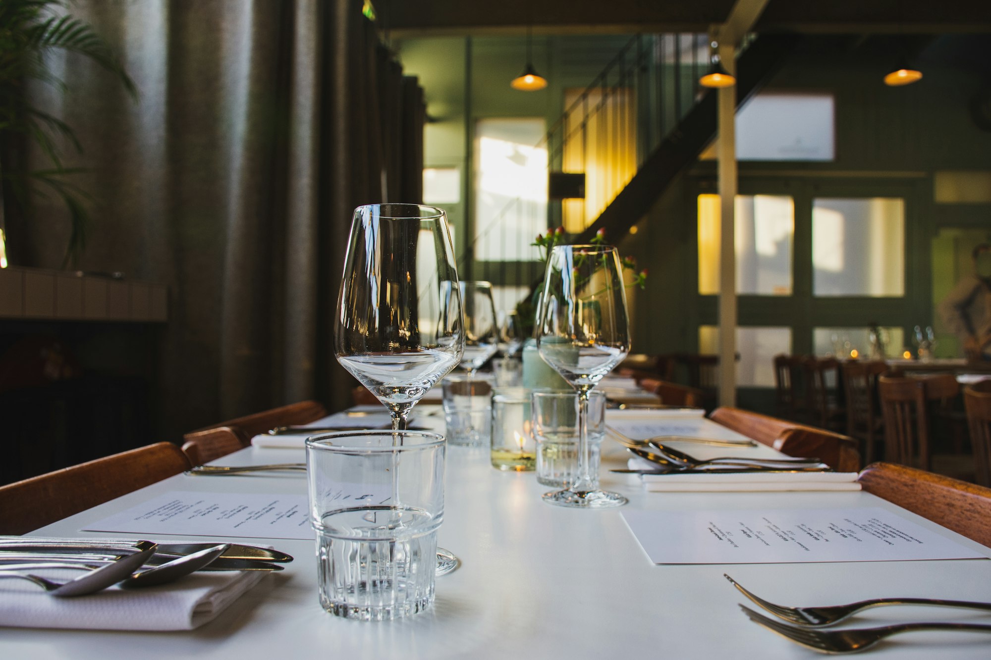 A restaurant table set for service with glassware and cutlery