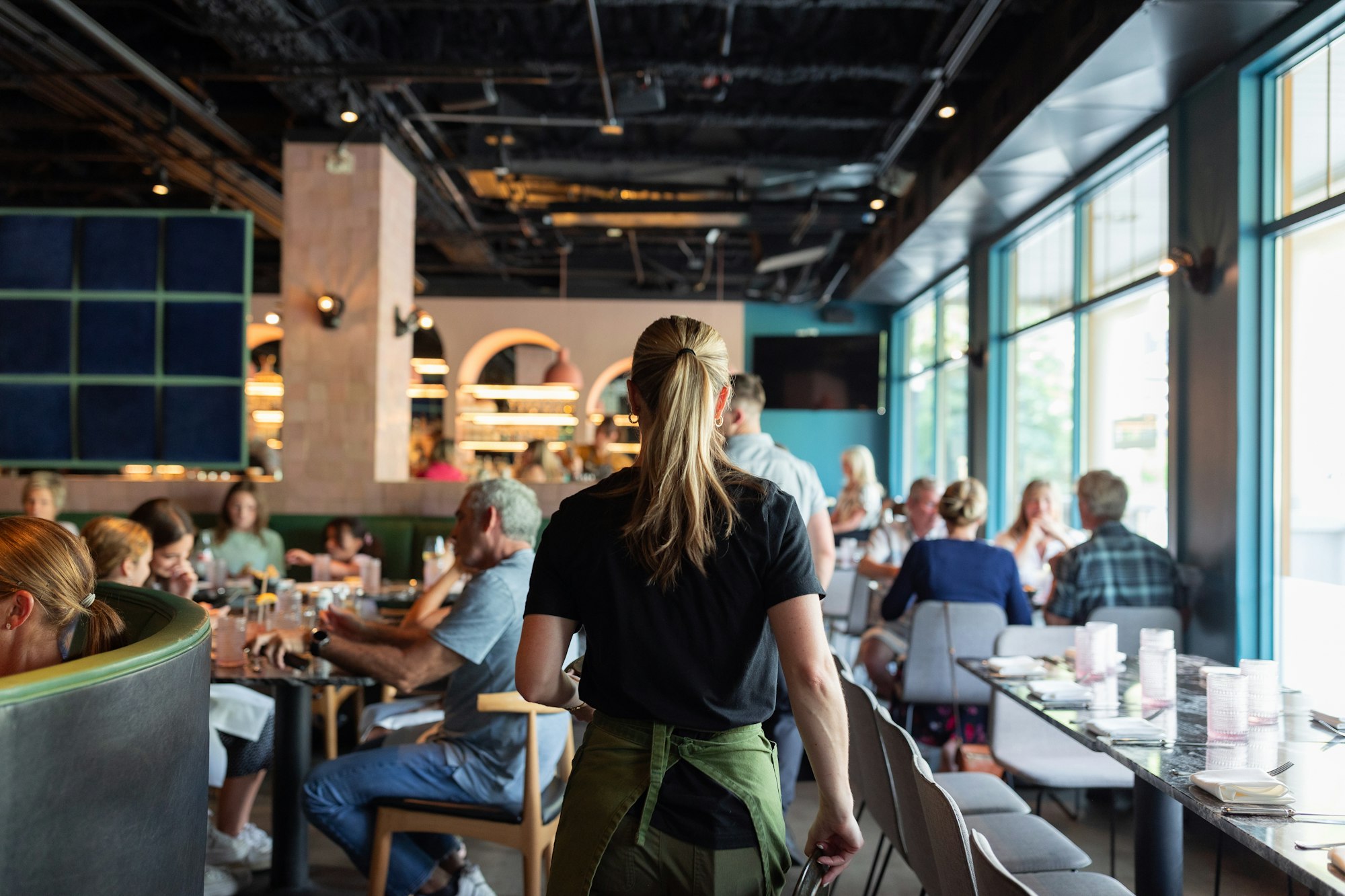 Service staff attending tables in a busy restaurant dining room