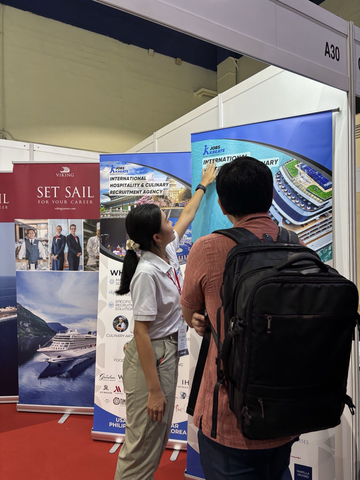 Jobs Kreate consultant showing the International Hospitality & Culinary Recruitment Agency banner to a candidate at Booth A30, myStarjob Fair 2026, Mid Valley Exhibition Centre Kuala Lumpur.