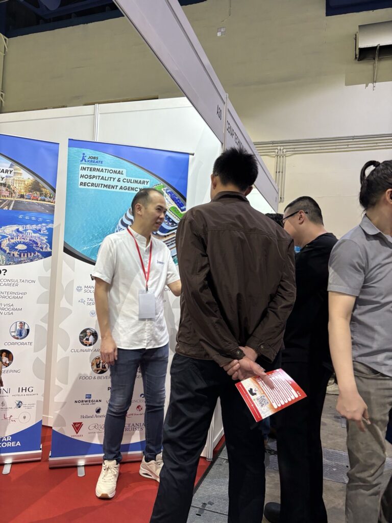 Jobs Kreate consultant in conversation with visitors holding Jobs Kreate brochures at Booth A30 during myStarjob Fair 2026.
