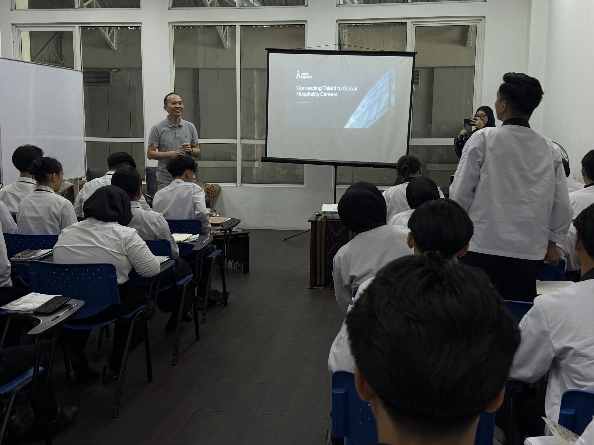 Keith from Jobs Kreate sharing cruise career insights with culinary students at Ascot Academy Kota Kinabalu, with the Jobs Kreate Connecting Talent to Global Hospitality Careers slide on screen.